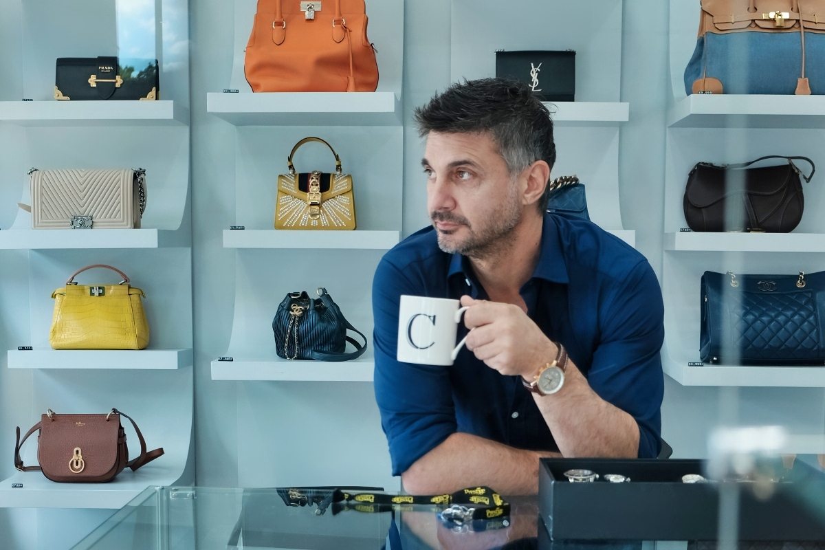 James Constantinou with designer handbags in background